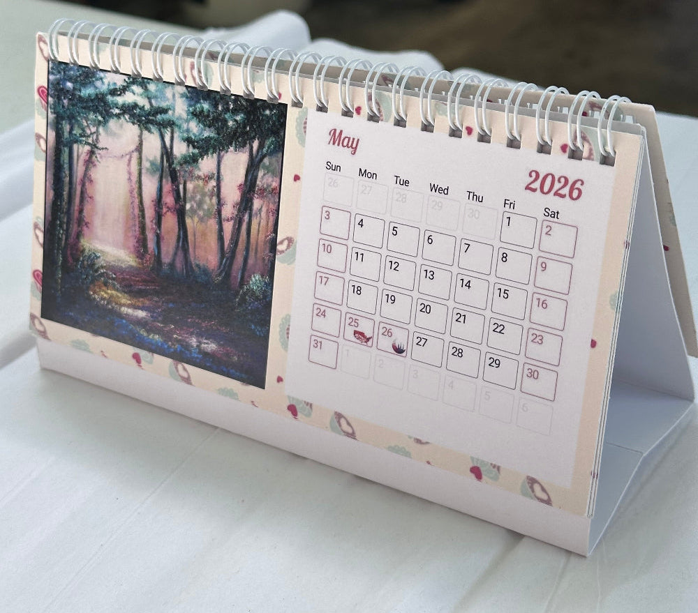 2026 faith-inspired desk calendar open to May, featuring an original forest painting by M. Thompson Art