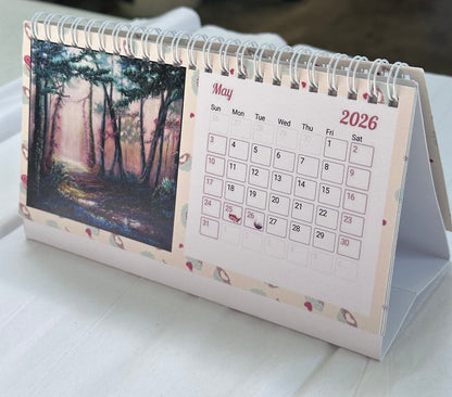2026 faith-inspired desk calendar open to May, featuring an original forest painting by M. Thompson Art