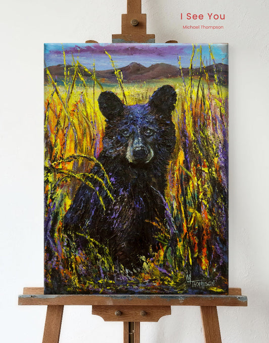 Painting of a bear in a field on an easel with 'I See You' by Michael Thompson text.