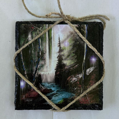 Small painting of a forest scene with a glowing light, tied with twine on a white background.
