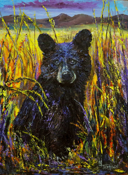 Painting of a bear cub in a grassy field with a colorful sky